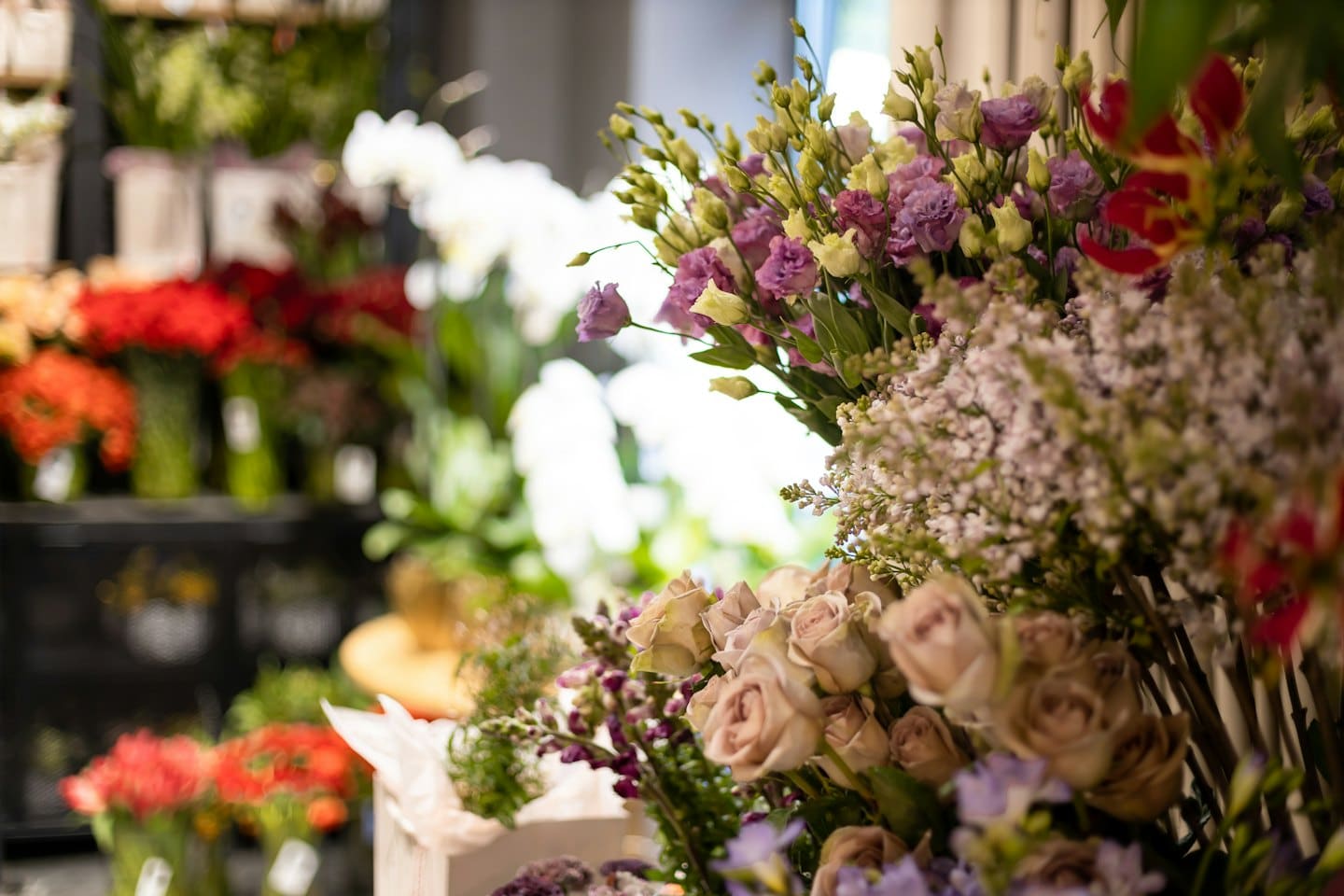 Pink roses, lisianthus, and baby's breath in a florist shop.