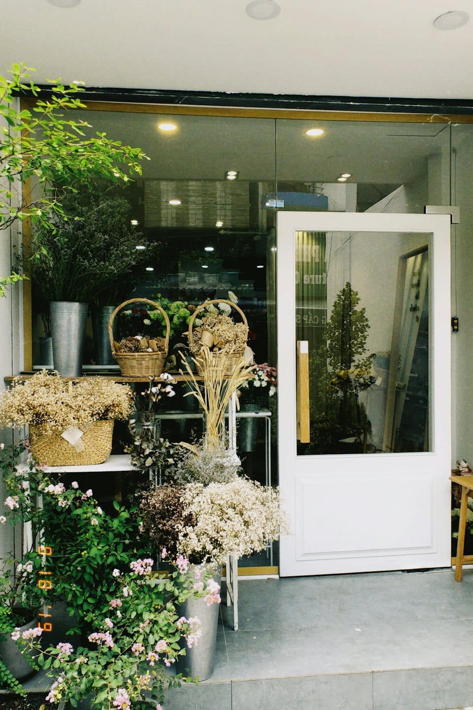 Floral arrangements fill the sidewalk outside a flower shop.